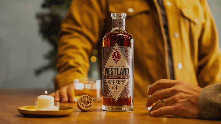 man with whiskey bottle by candlelight